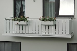 Balkongelnder Kunststoff Weiss mit senkrechten Profilen und Blumenkasten